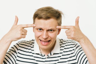 Parmağıyla şakağına dokunan öfkeli bir adamın yakın plan portresi. Delirdin mi sen??