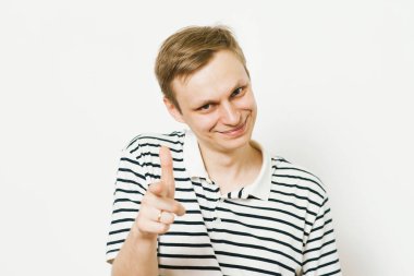 Genç adam işaret parmağını kameraya doğru gösteriyor.