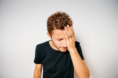  Adam elleriyle yüzünü kapatıyor.