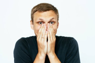 Adam gülüyor ve ağzını kapatıyor.