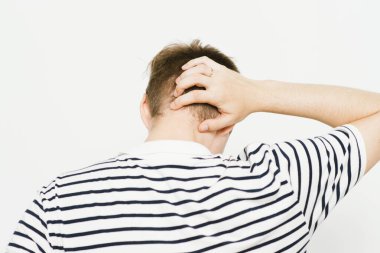 Kafasını tutarak. Arkadaki adam