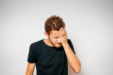  Adam elleriyle yüzünü kapatıyor.