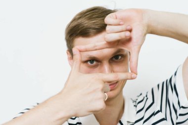 Adam fotoğraf stüdyosunda el çerçevesi yapıyor.