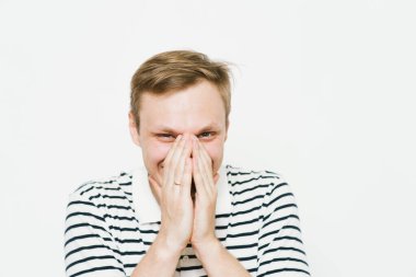 Adam gülüyor ve ağzını kapatıyor.