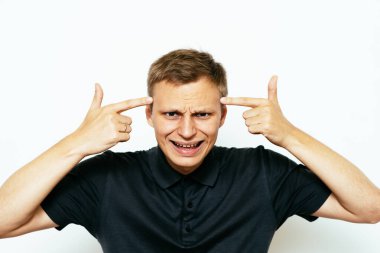 Parmağıyla şakağına dokunan öfkeli bir adamın yakın plan portresi. Delirdin mi sen??