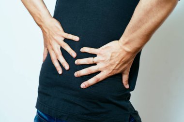 Fotoğraf stüdyosunda sırtı ağrıyan bir adam.