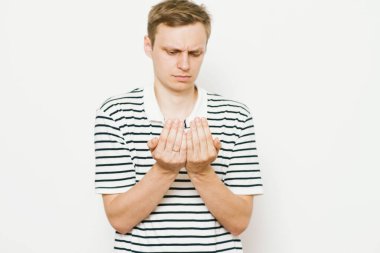 Yakışıklı adam avucunun içinde bir şey sunar.