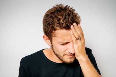  Adam elleriyle yüzünü kapatıyor.