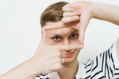 Adam fotoğraf stüdyosunda el çerçevesi yapıyor.