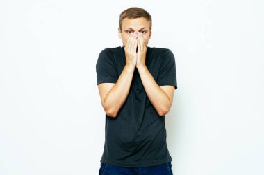 Adam gülüyor ve ağzını kapatıyor.