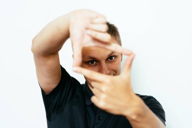 Adam fotoğraf stüdyosunda el çerçevesi yapıyor.