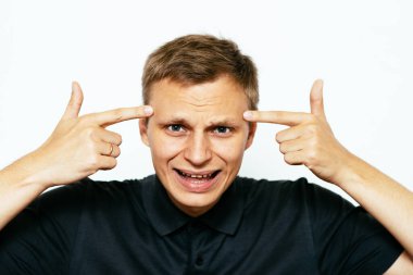 Parmağıyla şakağına dokunan öfkeli bir adamın yakın plan portresi. Delirdin mi sen??