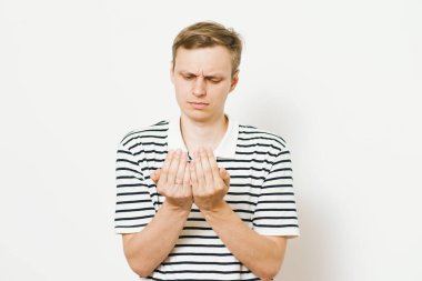 Yakışıklı adam avucunun içinde bir şey sunar.