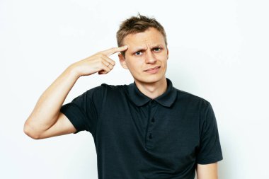 Parmağıyla şakağına dokunan öfkeli bir adamın yakın plan portresi. Delirdin mi sen??