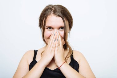 Kız gülüyor ve ağzını kapatıyor.