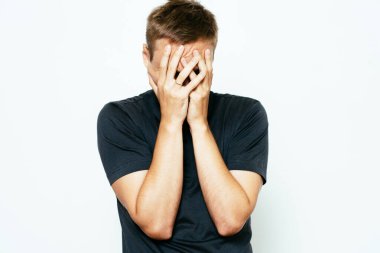 Adam elleriyle yüzünü örttü.