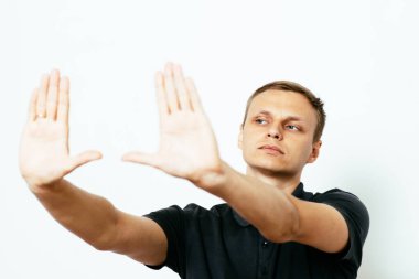 Adam fotoğraf stüdyosunda el çerçevesi yapıyor.