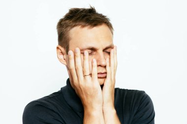 Adam elleriyle yüzünü örttü.