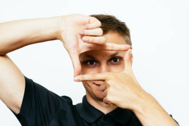 Adam fotoğraf stüdyosunda el çerçevesi yapıyor.