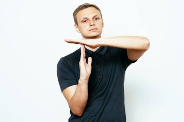 Bir adam, ellerin mola verdiğini gösterir. Gri bir arkaplanda.