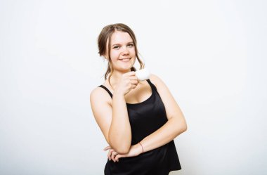 Stüdyo arka planında fincan olan kadın.