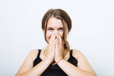 Kız gülüyor ve ağzını kapatıyor.