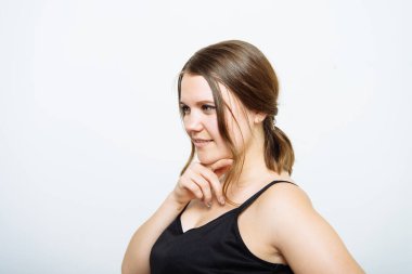 Kadın stüdyo arka planında düşünüyor.