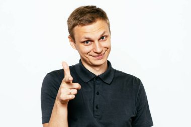 Genç adam işaret parmağını kameraya doğru gösteriyor.