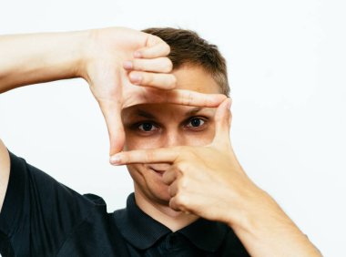 Adam fotoğraf stüdyosunda el çerçevesi yapıyor.