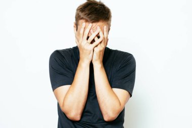 Adam elleriyle yüzünü örttü.