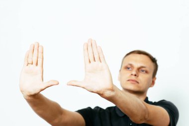 Adam fotoğraf stüdyosunda el çerçevesi yapıyor.