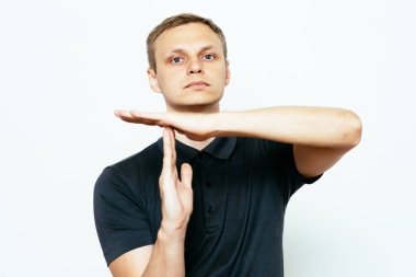 Bir adam, ellerin mola verdiğini gösterir. Gri bir arkaplanda.