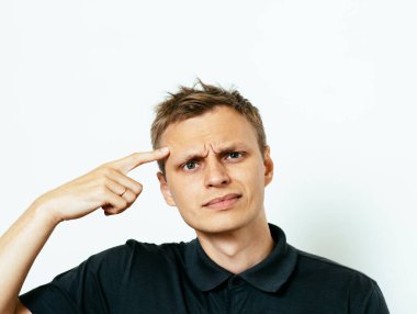 Parmağıyla şakağına dokunan öfkeli bir adamın yakın plan portresi. Delirdin mi sen??