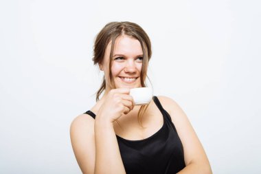 Stüdyo arka planında fincan olan kadın.