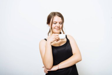 Stüdyo arka planında fincan olan kadın.