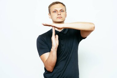 Bir adam, ellerin mola verdiğini gösterir. Gri bir arkaplanda.