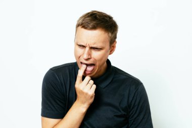 Avrupa görünümlü bir erkek kusmaya neden olur. Parmaklarını ağzına koyar, midesi bulanır.