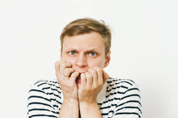 Человек кусает свои ногти