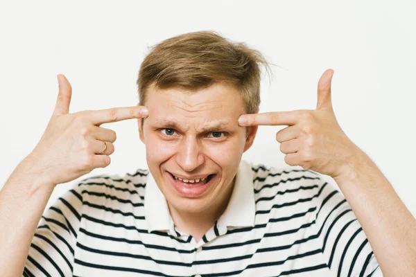 Parmağıyla şakağına dokunan öfkeli bir adamın yakın plan portresi. Delirdin mi sen??