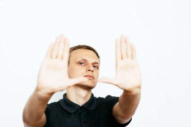 Adam fotoğraf stüdyosunda el çerçevesi yapıyor.