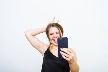 Bir kadın fotoğraf stüdyosunda selfie çekiyor.