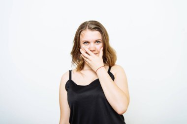 Kız gülüyor ve ağzını kapatıyor.