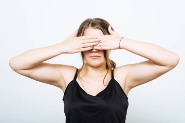 Kadın elleriyle gözlerini kapatıyor.