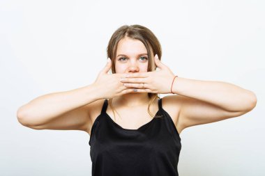 Başarılı stil sahibi kız ellerini kullanarak ağzını kapatıyor. Stüdyoda izole halde.