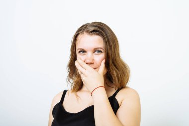 Kız gülüyor ve ağzını kapatıyor.