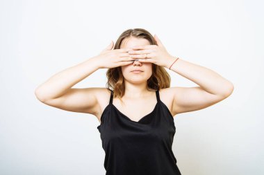 Kadın elleriyle gözlerini kapatıyor.