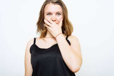 Kız gülüyor ve ağzını kapatıyor.