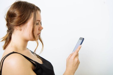 Fotoğraf stüdyosunda akıllı telefonu olan bir kadın.