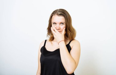 Kız gülüyor ve ağzını kapatıyor.