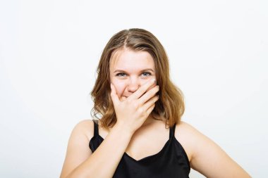 Kız gülüyor ve ağzını kapatıyor.